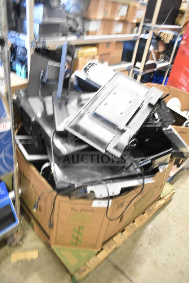 A variety of 27 computer monitors including Onn, Dell, and HP models piled in a cardboard container, auctioned as a lot.