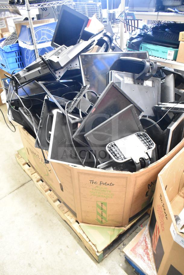 Box filled with assorted computer monitors, including Onn, Dell, and HP; some are stacked; condition varies.