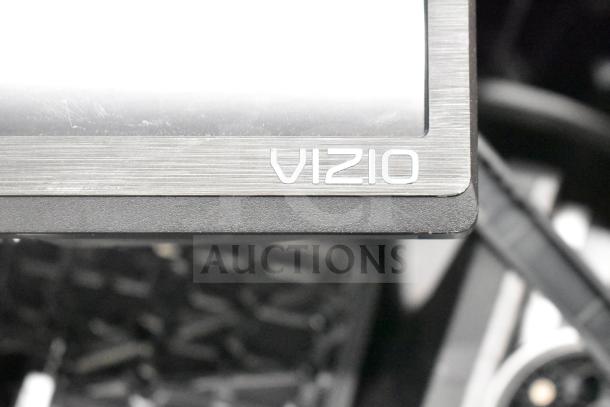 Close-up of a Vizio monitor with a silver trim displaying a reflective screen. Model details not visible.
