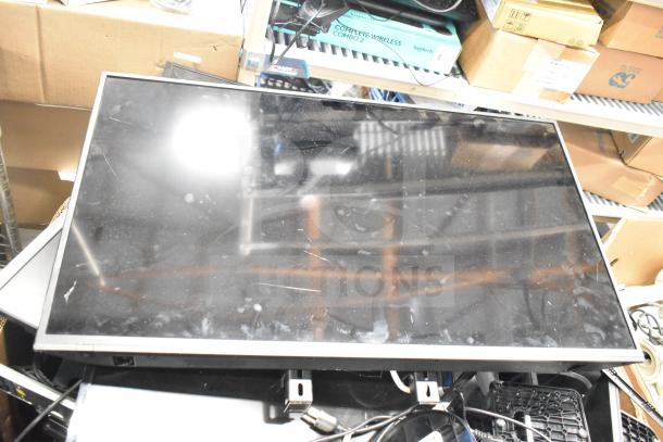 Assorted electronics including Onn, Dell, and HP monitors. Visible signs of wear, stacked on a shelf.