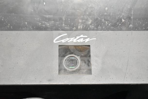 Black Costar device with lens and logo, featuring a scratched surface. Part of 27 mixed-item auction lot.