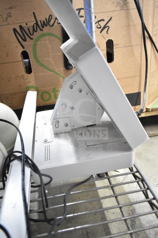 Security system setup with two monitors and cameras, mounted on a metal stand, in used condition. Visible cables included.