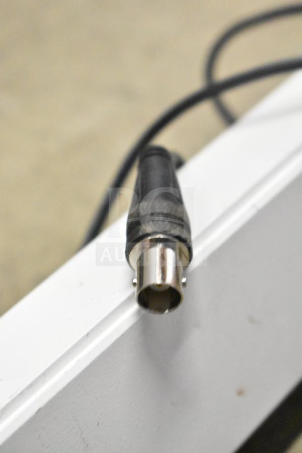Close-up of a security system coaxial cable connector. Item condition appears good, suitable for monitors and cameras setup.