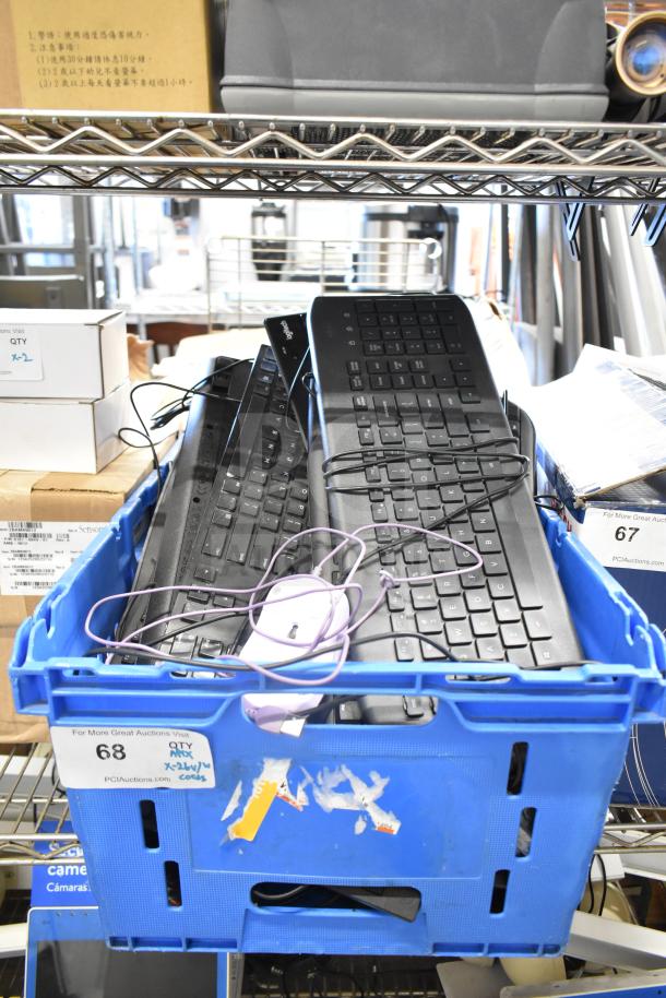 Blue crate containing various keyboards and a wired mouse. Includes Logitech models. Condition unknown. Auction lot 68.