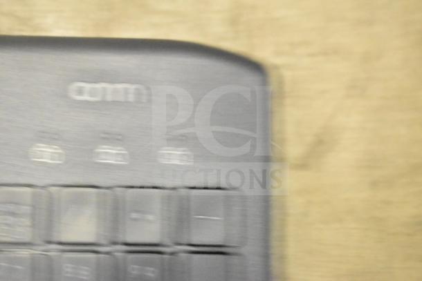A blurry close-up of a keyboard, part of a lot including 26 various items like keyboards and mice for auction.