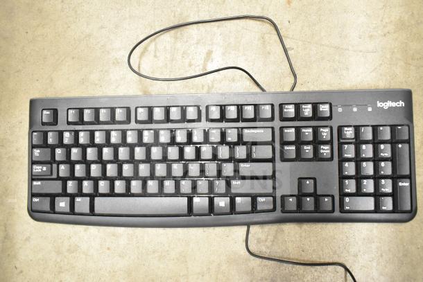 Logitech keyboard with wired connection, QWERTY layout, and numeric keypad. Slight wear visible, suitable for office use.