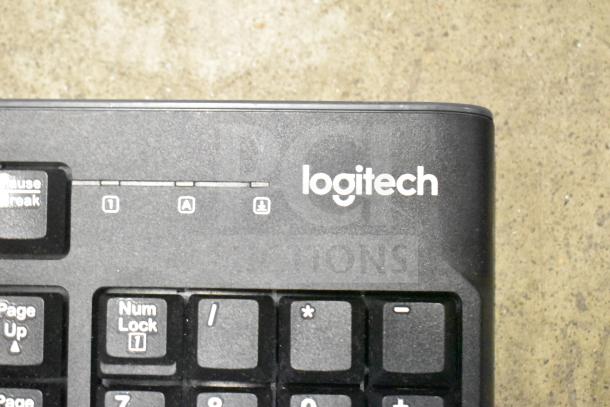 Logitech keyboard close-up, part of a 26-item auction lot including keyboards and mice, logo visible.