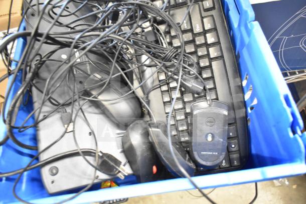 Blue bin filled with 26 computer items, including Dell keyboards and mice, tangled cables visible. Auction lot.