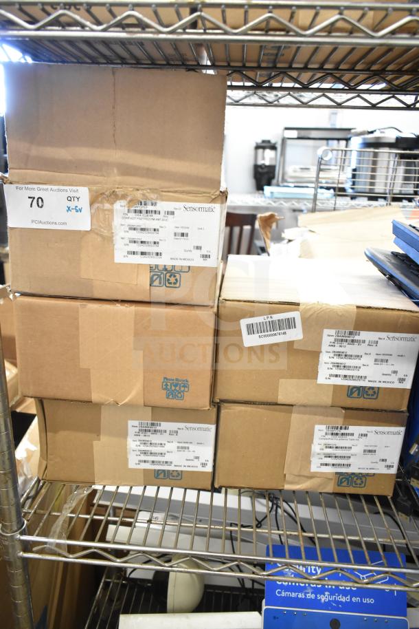 Cardboard boxes on metal shelves labeled with Sensormatic ZBSMPCPEF Compact Pad Pro. Includes auction lot tags and details.