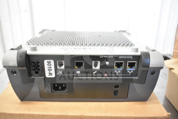 Sensormatic ZBSMPCPEF Compact Pad Pro, black, showing back ports and label "9010-R", resting on cardboard box.