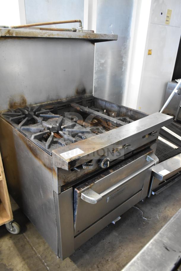 Garland commercial 6 burner range with oven, over shelf, and backsplash. Used condition, stainless steel exterior.