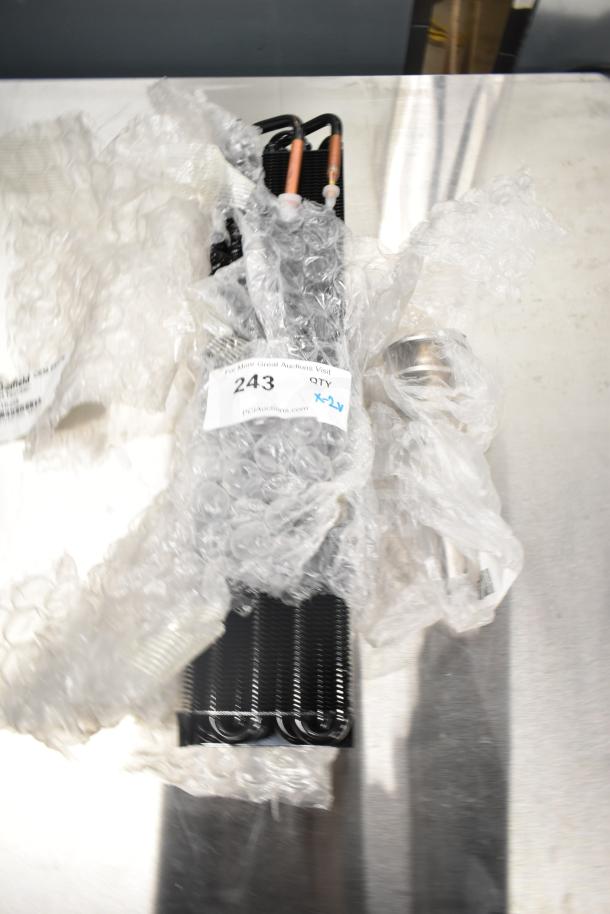 Two new items: Avantco 177PMG225 Auger and Evaporator Coil, wrapped in bubble wrap, auction tag "243" visible.