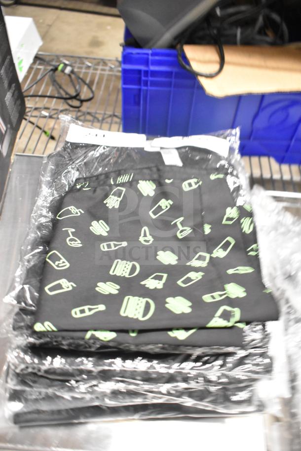 Seven brand new, packaged Shack Staff Tees in various sizes, featuring a black design with light green graphics.