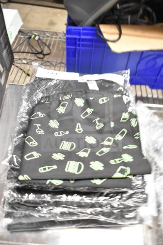 Seven brand new, packaged Shack Staff Tees in various sizes, featuring a black design with light green graphics.