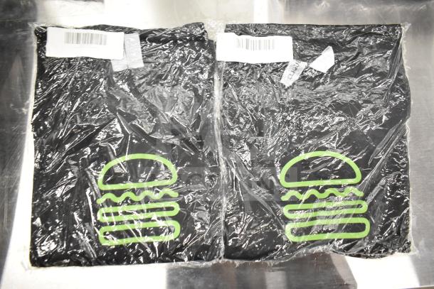 Brand new Shack Staff tees in original packaging. Includes sizes XL, MD, 2XL with green burger logo. Barcoded labels visible.
