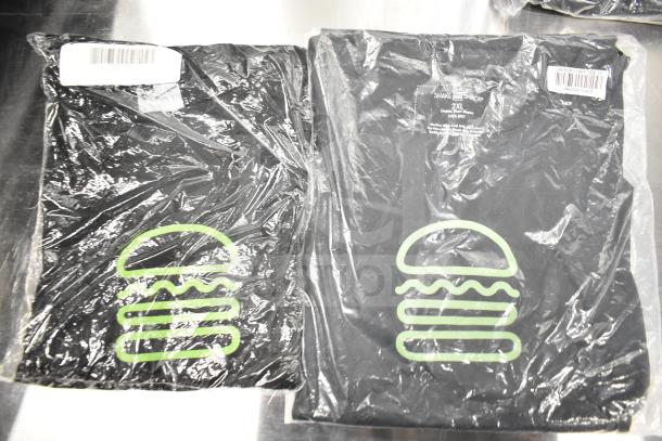7 brand new Shack Staff Tees, sizes XL, MD, 2XL in packaging. Black with green logo. Scratch and dent sale.