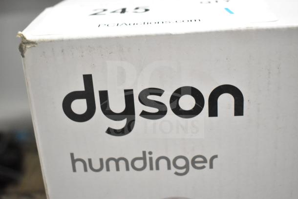 Box of Dyson Humdinger Vacuum Cleaner, features brand logo and product name. Box shows slight wear. Auction label present.
