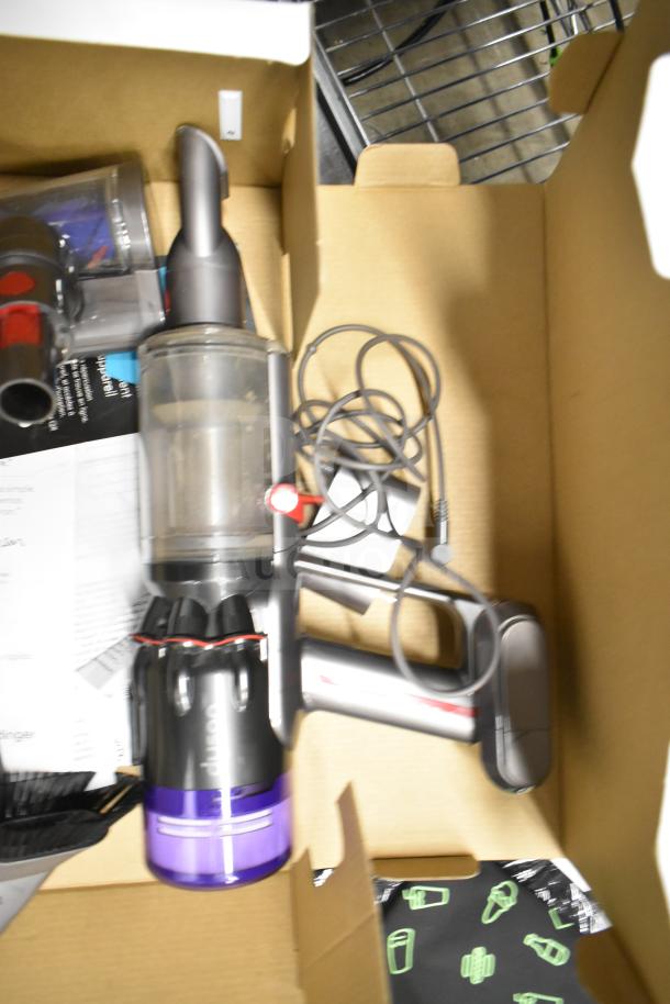 Dyson Humdinger Vacuum Cleaner in original packaging, lightly used, includes attachments and charging cable.