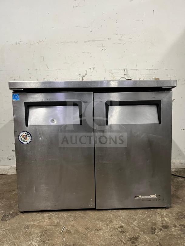 True TUC-36 undercounter cooler, stainless steel, two doors, visible dents and wear, label on front.