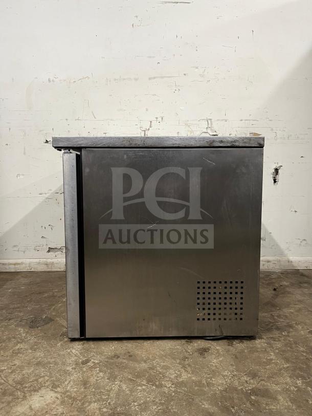 True TUC-36 undercounter cooler, stainless steel, two doors, visible wear, sturdy construction, model TUC-36.