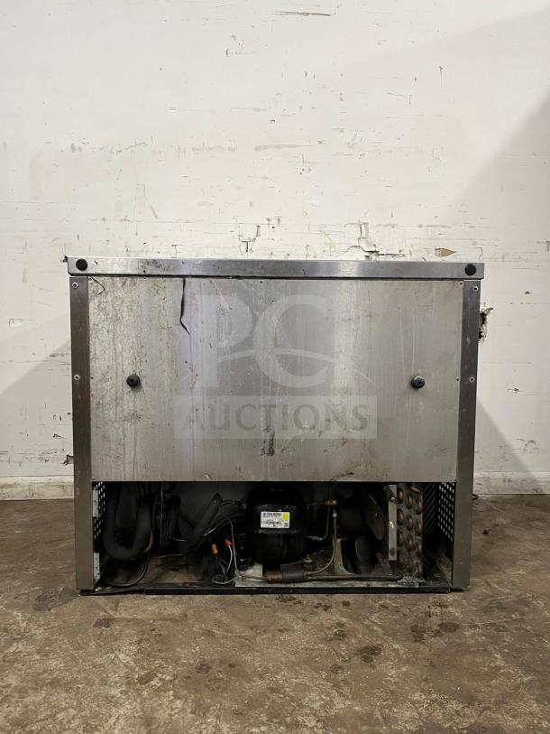 True TUC-36 undercounter cooler, stainless steel, two doors, visible wear, exposed compressor, True model label present.