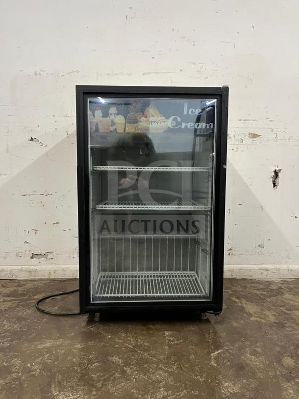 Countertop display freezer with glass door, two wire shelves. Ice cream graphics on top. Good condition. Ideal for retailers.