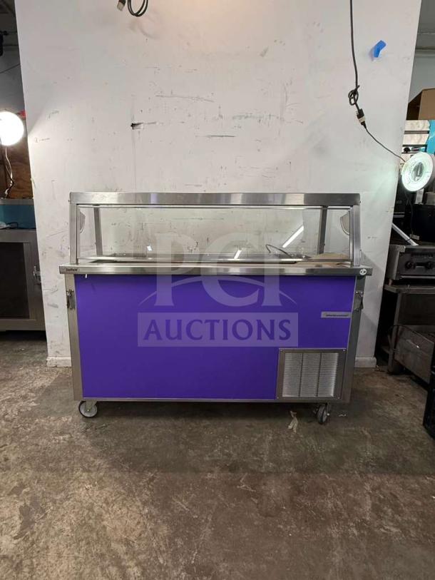 Brand new Delfield SCSC-60-EFP 60-inch refrigerated food prep table with stainless steel top, glass cover, and mobile casters.
