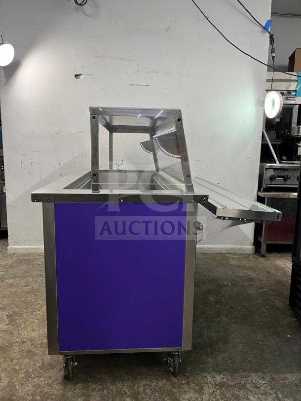 Brand new Delfield SCSC-60-EFP refrigerated food prep table, 60-inch, purple panel, stainless steel, on wheels.