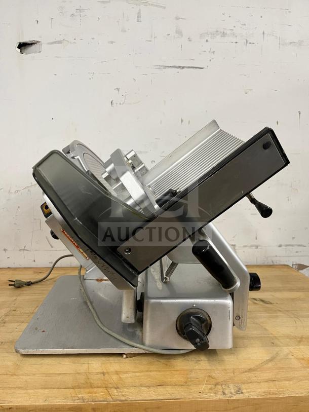 Steel Manual Food Slicer, robust design, side view, used condition, visible power cord, adjustable thickness control knob.
