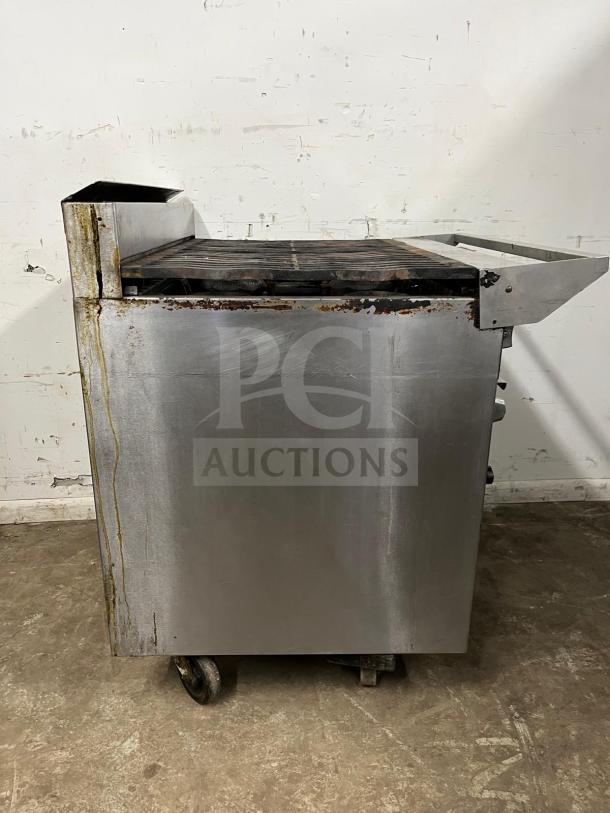 Jade Range Oven, 6 Burners, 35000 BTU, stainless steel, visible rust and wear, model: oven, on wheels for mobility.