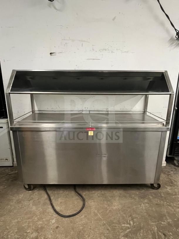 Stainless steel Gaylord hot food steam buffet table, model buffet table, with glass display. Features include a heating element, wheels, and a caution label.