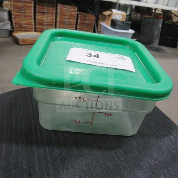 2 Quart food storage container with green lid. Marked measurements up to 1.5L. Auction label "34" visible. Good condition.
