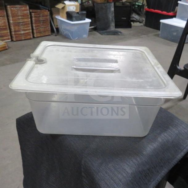 1/2 size, 6-inch deep clear food storage container with lid, in good condition. Ideal for kitchen or commercial use.