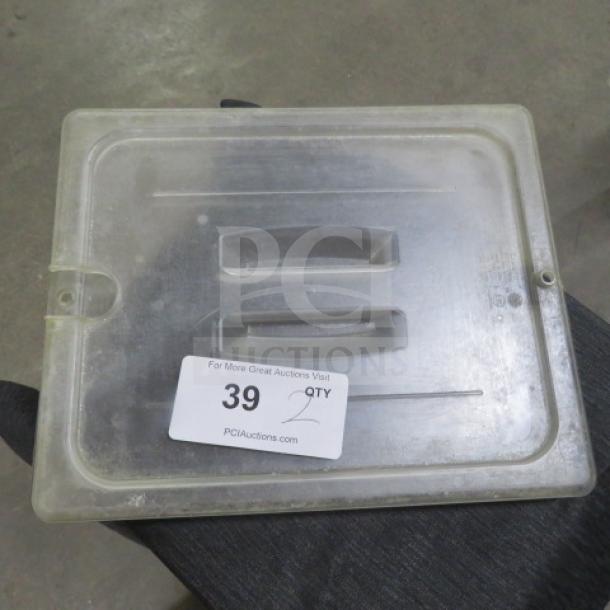 Clear 1/2 size food storage lid with two built-in handles, marked "2XBID," showing light wear. Auction tag #39 visible.