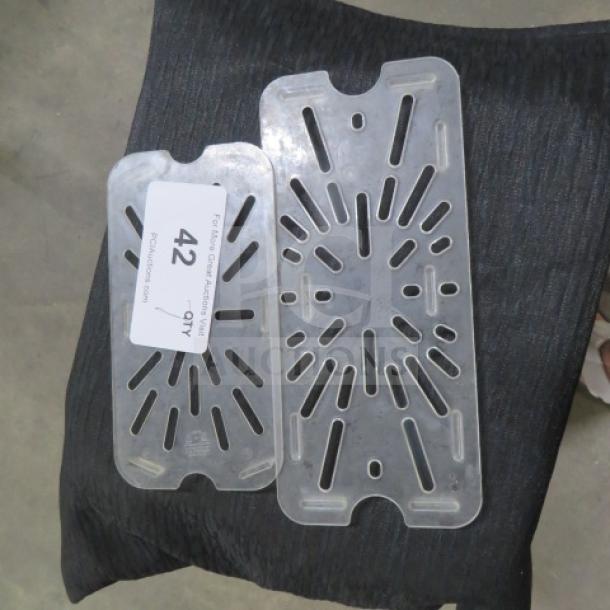 Assorted size clear plastic drain shelves, two pieces, with slotted design. Tag marked "42" and "7XBID". Excellent condition.