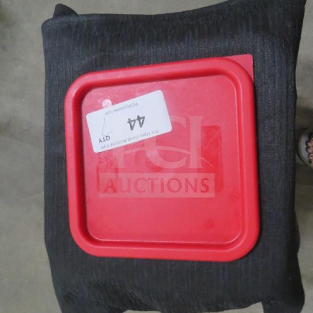 Red 6/8 quart food storage lid labeled "7XBID," in good condition, on a black cushion.