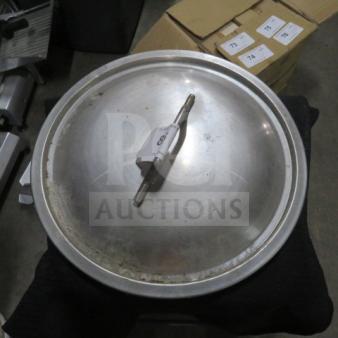 Metal lid with central handle, used condition, possible wear on surface. Attached label with number 79.