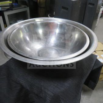 Assorted size stainless steel mixing bowls, slightly used, reflective surface, nested for compact storage.