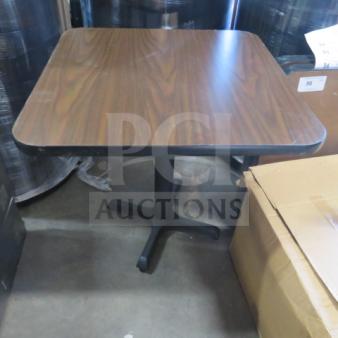 One laminate table top with pedestal base, 30x30x30 inches, woodgrain finish, used condition.