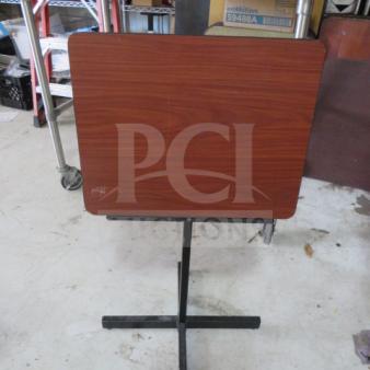 Wooden music stand with metal base, minor scratches on surface, adjustable height, sturdy condition.