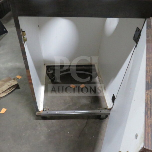 Wood-veneered trash receptacle on casters, open door, size 27x27x40 inches, shows interior structure and hardware.