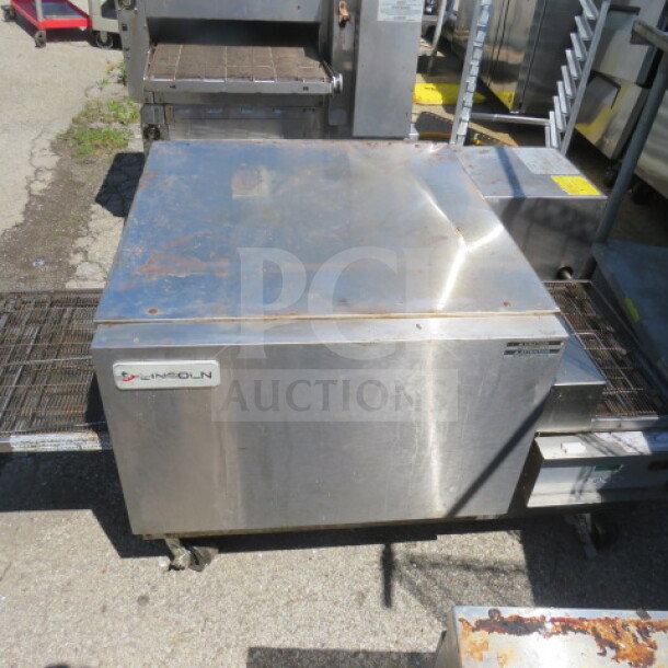 Lincoln conveyor pizza oven on casters, 38x57x26.5 inches. Stainless steel, working condition when removed.