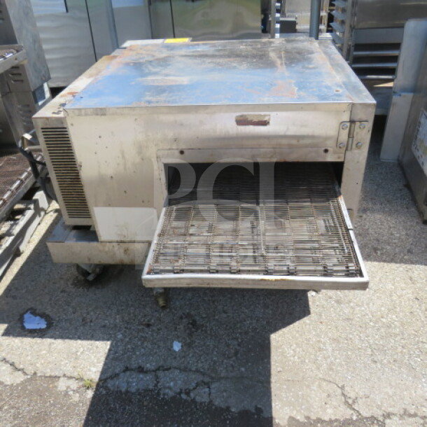Lincoln conveyor pizza oven on casters, 38x57x26.5, shows wear, functioning when removed, visible rust spots.