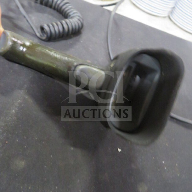 Honeywell 1900 handheld scanner, used, with visible wear. Black with a coiled cable. Suitable for barcode scanning.