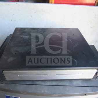 Black cash drawer with metal front panel, lightly used, visible scratches on top, standard size.