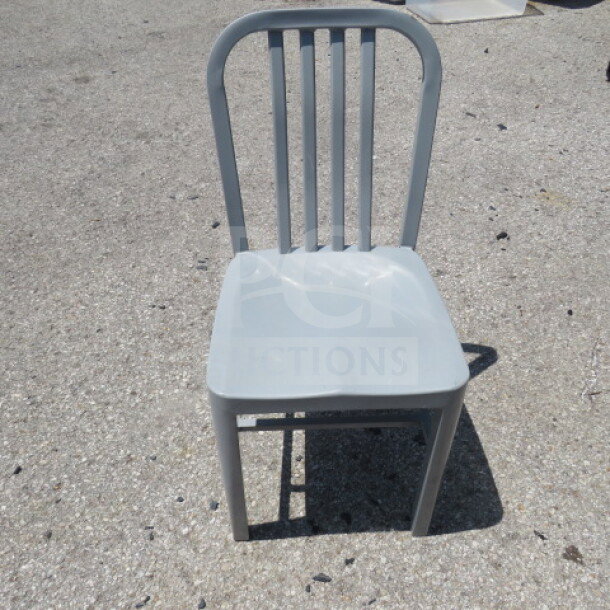 Silver metal chair with a slatted back, suitable for indoor or outdoor use; sturdy and in good condition.