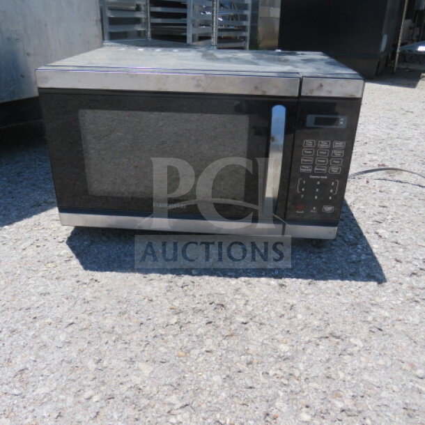 Faberware Microwave, Model FM011AHTBKM, 120V, 20.5x14.5x12, black and silver, visible control panel, fair condition.