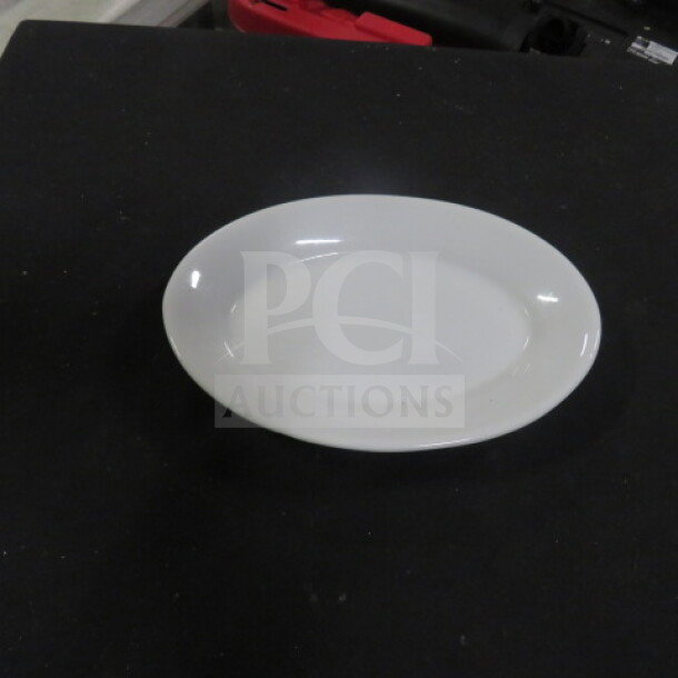 White 8x6 oval plate in excellent condition, smooth finish, on black surface.