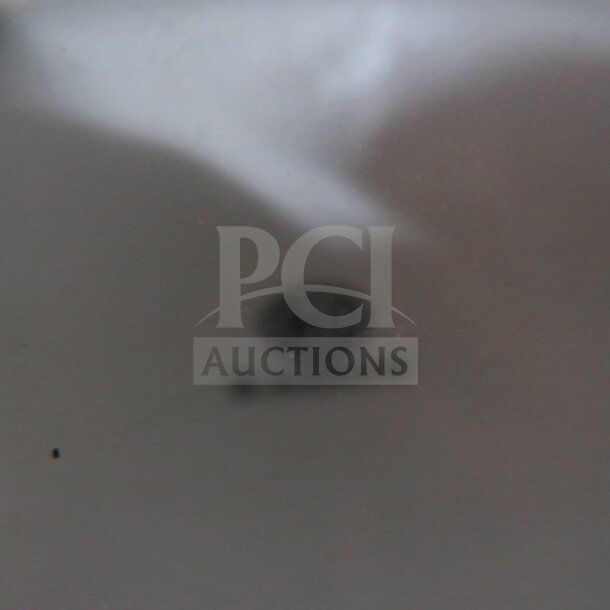 Blurry logo mark on a white oval plate, possibly indicating brand or maker.