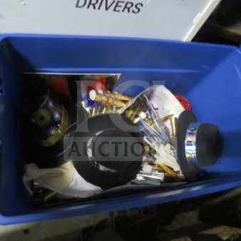 Large blue bin containing assorted decorative items, including black hats, shiny decor, and various metallic pieces.
